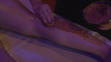 Rahatlamış genç bir kadın kaplıcada çamurdan cilt tedavisi görüyor. Güzellik merkezinde güzellik uzmanı tarafından kilden maske taktıran güzel bir genç kadının portresi..