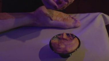 Rahatlamış genç bir kadın kaplıcada çamurdan cilt tedavisi görüyor. Güzellik merkezinde güzellik uzmanı tarafından kilden maske taktıran güzel bir genç kadının portresi..