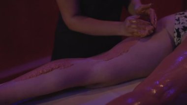 Rahatlamış genç bir kadın kaplıcada çamurdan cilt tedavisi görüyor. Güzellik merkezinde güzellik uzmanı tarafından kilden maske taktıran güzel bir genç kadının portresi..