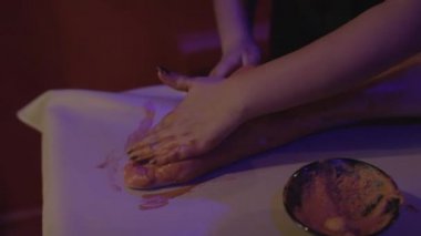 Rahatlamış genç bir kadın kaplıcada çamurdan cilt tedavisi görüyor. Güzellik merkezinde güzellik uzmanı tarafından kilden maske taktıran güzel bir genç kadının portresi..