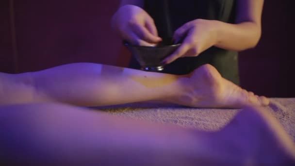 Masażysta Wylewający Olejek Masażu Nogę Młodej Kobiety Spa — Wideo stockowe