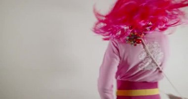 Komik, sevimli, mutlu çocuk mikrofonla şarkı söylüyor. Güneş gözlüğü ve pembe peruk takıp müzik eşliğinde dans ediyor.