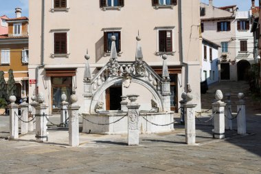 Koper 'in merkezindeki tarihi Da Ponte Çeşmesi. Kuyu şeklinde ve taş aslanlarla süslenmiş.