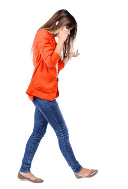 hareket eden telefon ile yürüyen bir kadın yan görünüm.