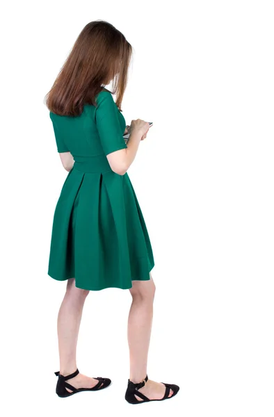Bakifrån stående ung vacker kvinna med en mobil phon — Stockfoto