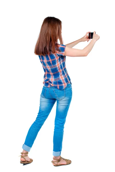 Back view of standing young beautiful  woman  using a mobile pho — Stock Photo, Image