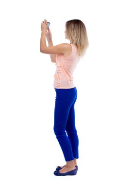 Arkadan Görünüm, genç güzel kadın ayakta ve cep telefonu kullanarak