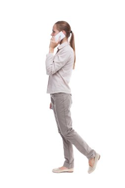 hareket eden telefon ile yürüyen bir kadın yan görünüm.