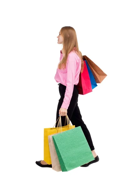 Achteraanzicht van lopende vrouw met shopping tassen — Stockfoto