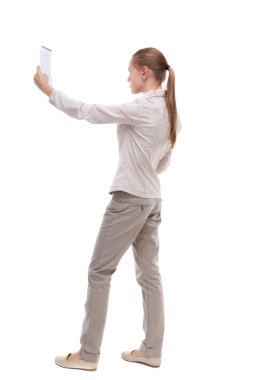 back view of  stands woman takes notes in a notebook. girl  watc