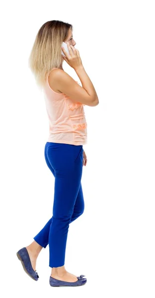 Side view of woman walking with a mobile phone. — Stockfoto