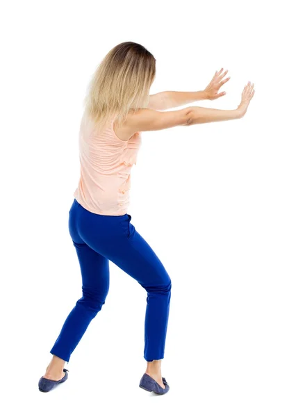 Back view of woman pushes wall. — Stock Photo, Image