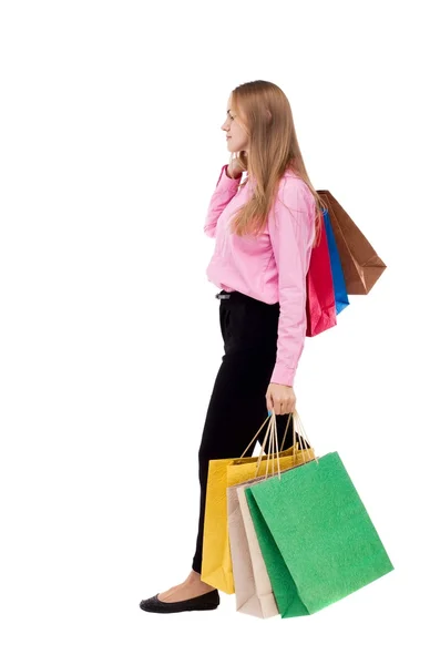 Achteraanzicht van lopende vrouw met shopping tassen — Stockfoto