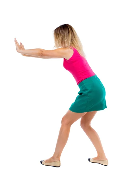 Back view of woman pushes wall. — Stock Photo, Image