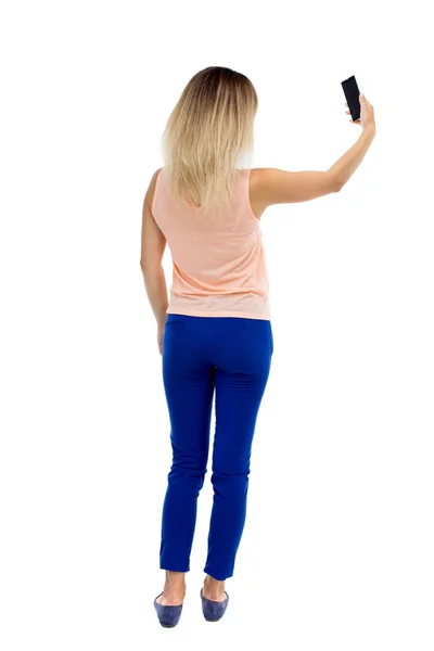 Back view of standing young beautiful  woman  and using a mobile — Stock Photo, Image