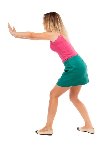 Back view of woman pushes wall. — Stock Photo, Image