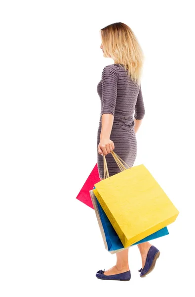 Vista trasera de la mujer que va con bolsas de compras — Foto de Stock