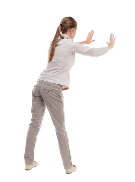 Back view of woman pushes wall. — Stock Photo, Image