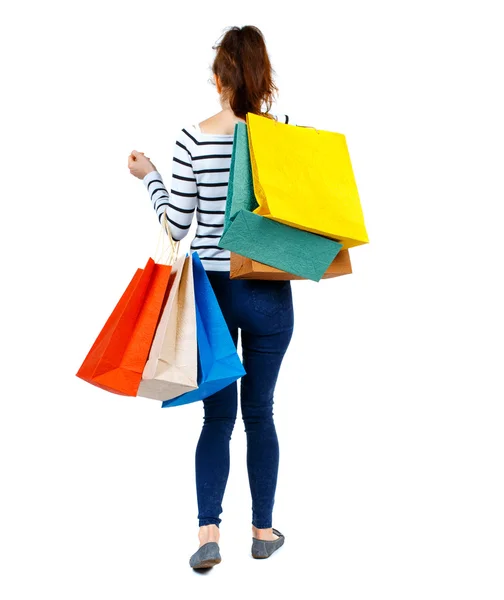 Visão traseira de ir mulher com sacos de compras  . — Fotografia de Stock