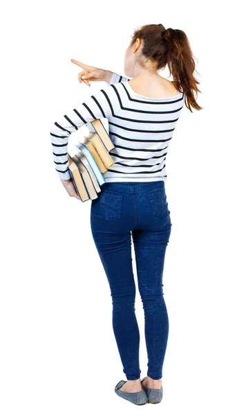 Dziewczyna z stos książek wskazuje palcem. — Zdjęcie stockowe