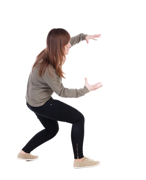 Back view of woman protects hands from what is falling — Stock Photo, Image