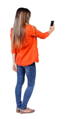 arkadan görünüşü bir mobil pho kullanan duran genç güzel kadın