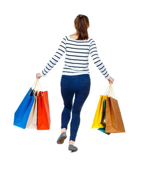 Back view of a woman jumping with shopping bags. — Stok fotoğraf