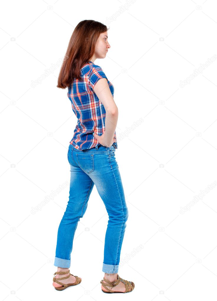 Girl in plaid shirt standing sideways with hands on hips. 