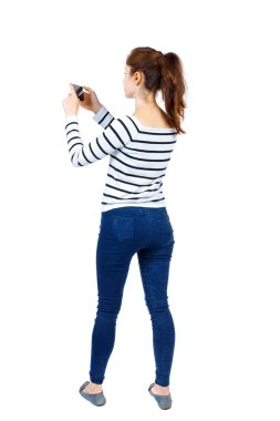 arkadan görünüşü bir mobil pho kullanan duran genç güzel kadın