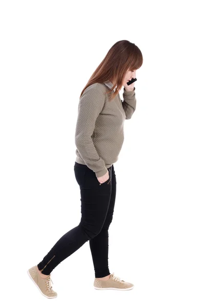 Sidovy av kvinna promenader med mobiltelefon. — Stockfoto