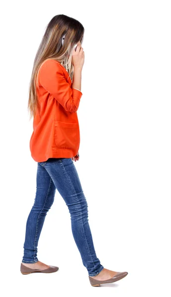 Zijaanzicht van een vrouw lopen met mobiele telefoon. — Stockfoto