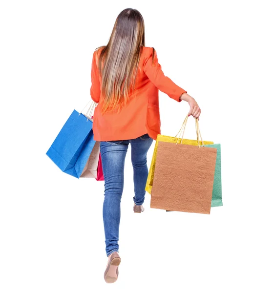 Back view of a woman jumping with shopping bags. — Fotografia de Stock