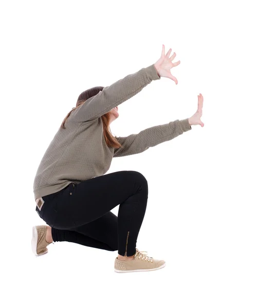 Back view of woman protects hands from what is falling — Stock Photo, Image