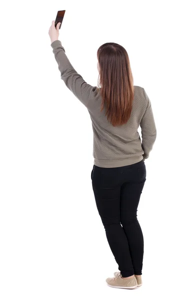 Back view of standing young beautiful  woman  using a mobile pho — kuvapankkivalokuva