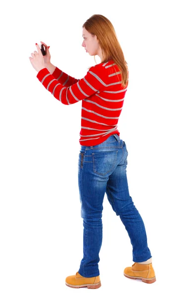 Back view of standing young beautiful  woman  using a mobile pho — Stock Photo, Image