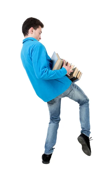 Ein Mann trägt einen schweren Haufen Bücher. — Stockfoto