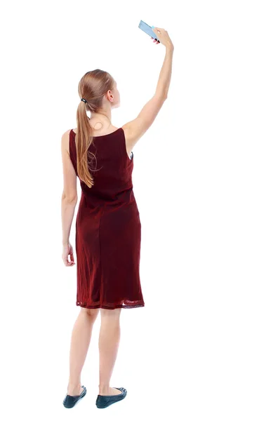 Back view of standing young beautiful  woman  using a mobile pho — Stock Photo, Image