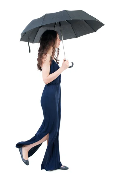 Νεαρή γυναίκα στο φόρεμα περπάτημα κάτω από μια ομπρέλα. — Φωτογραφία Αρχείου