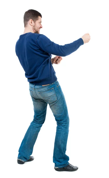 Back view of standing man pulling a rope from the top or cling t — Stock Photo, Image