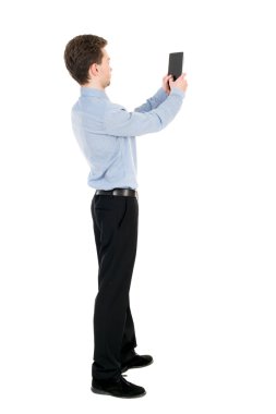 arkadan görünüşü ayakta iş adamı bir telefon veya tabl fotoğraf çekimi