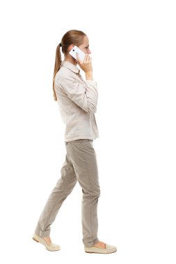 side view of woman walking with a mobile phone.