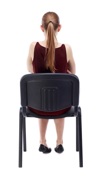 Back view of young beautiful  woman sitting on chair. — Stock Photo, Image