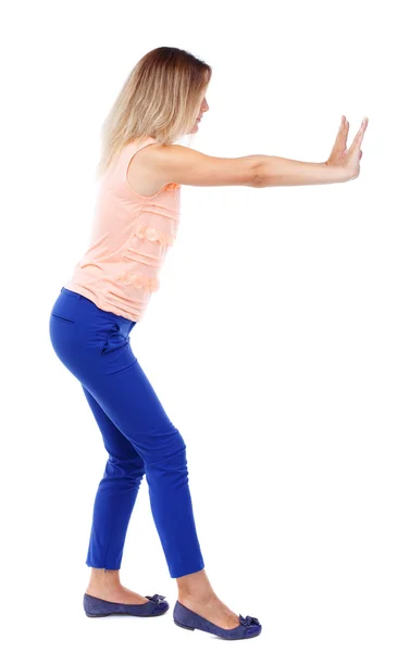 Back view of woman pushes wall. — Stock Photo, Image