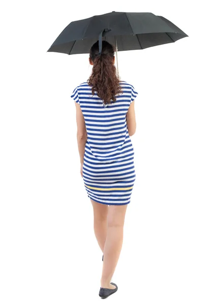 Jovem mulher de vestido andando sob um guarda-chuva. — Fotografia de Stock