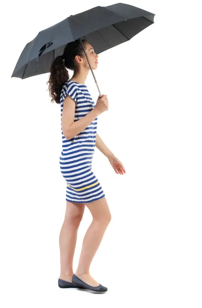 Jovem mulher de vestido andando sob um guarda-chuva. — Fotografia de Stock