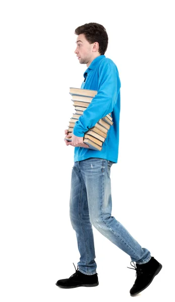 Side view of going  man carries a stack of books. — Stock Photo, Image