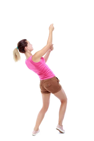 Back view of standing girl pulling a rope from the top or cling — Stock Photo, Image