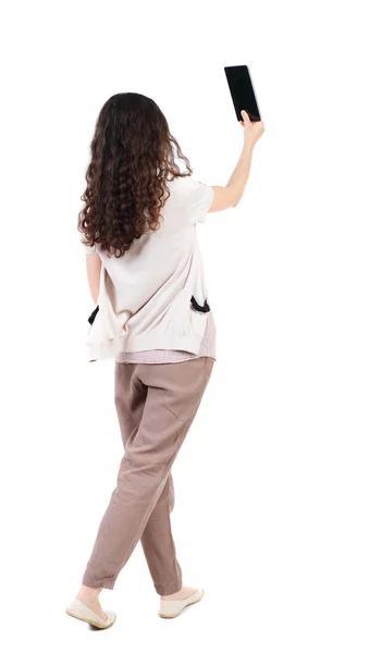 Back view of standing young beautiful  woman  using a mobile pho — Stock Photo, Image