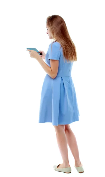 Vista posteriore di giovane donna bella in piedi utilizzando un fon mobile — Foto Stock