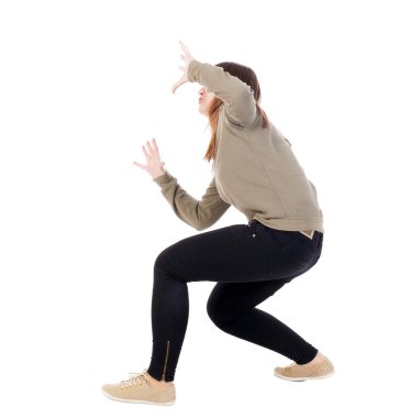 Side view. girl sat on his hands defensively on top of something